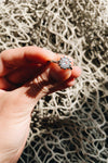 Woman holding sterling silver ring with white stone