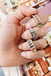 The vibrant yellow stone is off centered followed by white stones on ak sterling silver ring