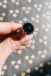 A dazzling black zircon stone is set in a sterling silver frame and band.