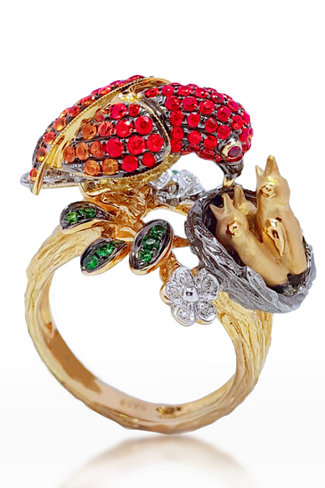 14kt yellow gold bird ring with red gemstone head, green stones, and white flower details
