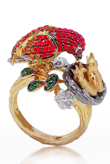 14kt yellow gold bird ring with red gemstone head, green stones, and white flower details
