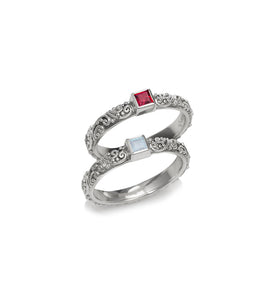 Sterling silver ring set with ornate filigree and two square gemstone insets, red and clear