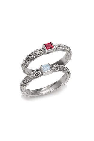 Sterling silver ring set with ornate filigree and two square gemstone insets, red and clear