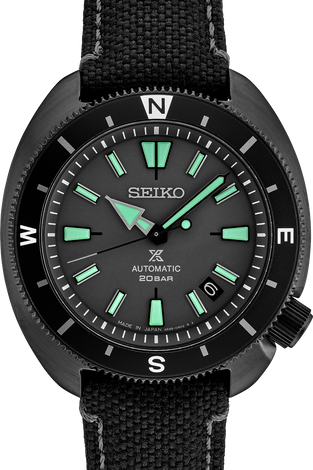 Men's black automatic watch with green indices, black bezel, and fabric strap.