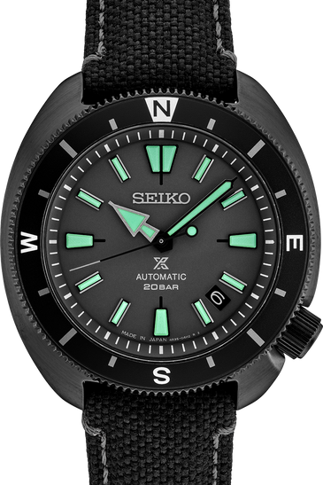 Men's black automatic watch with green indices, black bezel, and fabric strap.