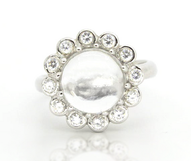 Sterling silver ring with white topaz cabochon and round halo of small stones